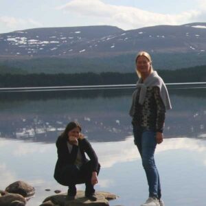 Carla en Patricia staan op stenen in een meer
